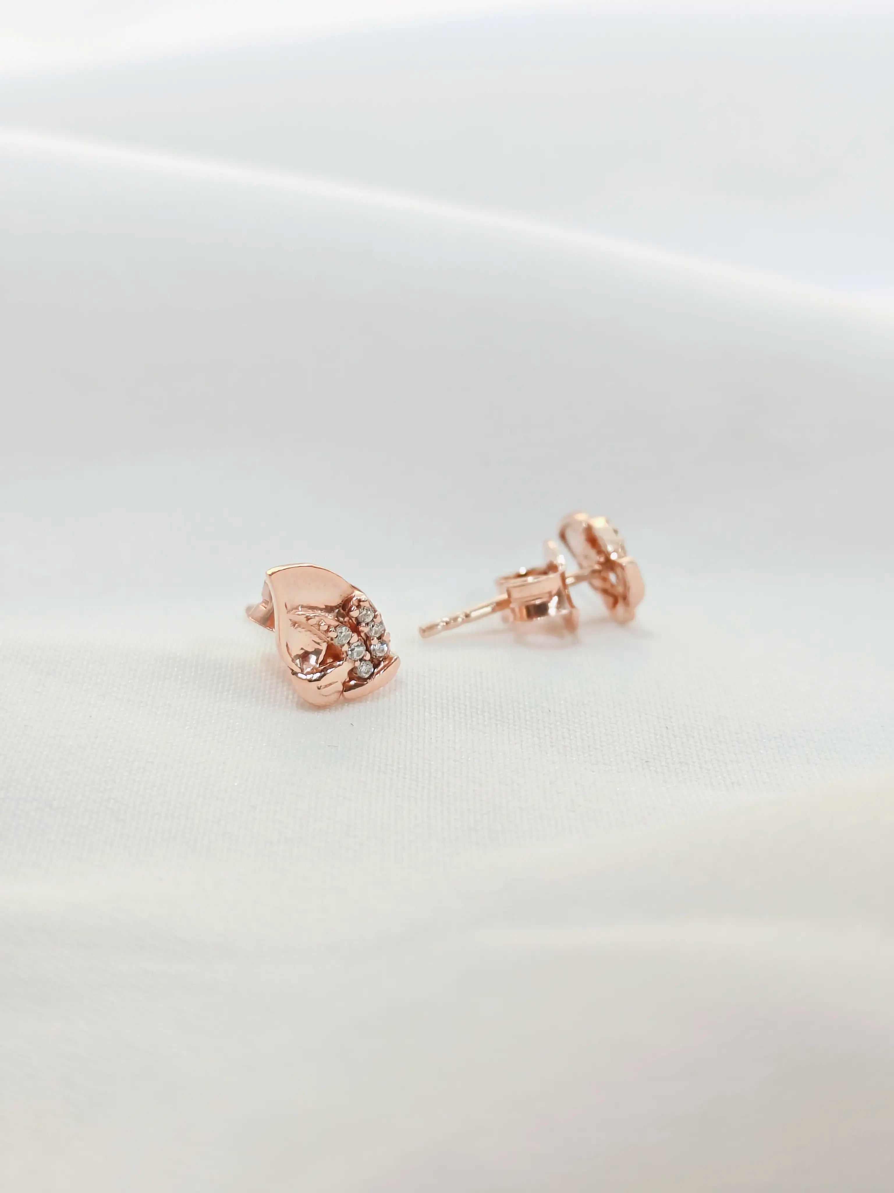 Rose gold earrings on a light gray background